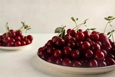 Ripe cherries in a plate on a light background Stock Photos