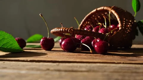 Ripe cherries in a small basket close-up on a wooden table Stock Footage 197672630