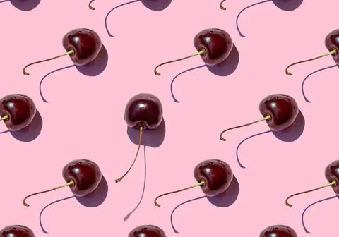 Ripe cherry berries seamless pattern on pink background. Stock Photos