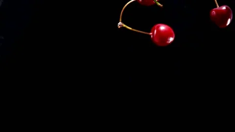 Ripe cherry drops on a black background Video stock 108390318