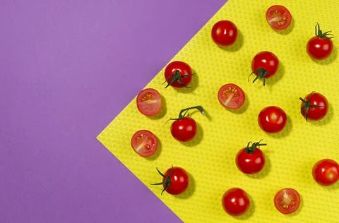 Ripe cherry tomato with shadow on geometric yellow dotted corner and purple b Stock Photos