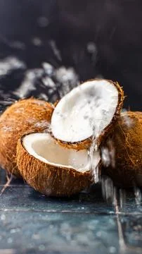 Ripe coconut, split in half, laying on a floor covered in coconut shavings and s Stockfoto's