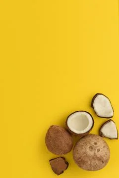 Ripe coconuts on yellow background. Pop art design, creative summer concept Stock Photos