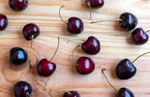 Ripe, delicious cherries lying on a table made of natural wood Stock Photos