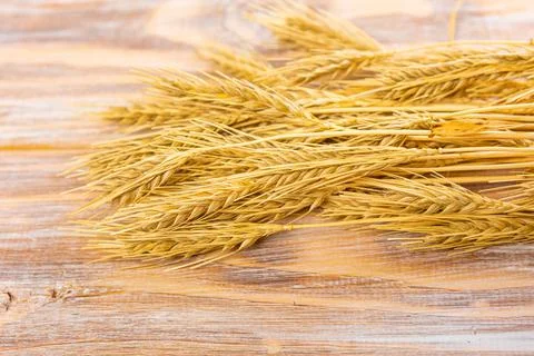Ripe ears of wheat on the background of an old wooden table. Top view, flat l Foto stock