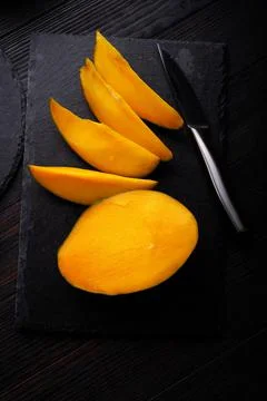 Ripe egyption Mango slices served  at black dish. close up Stock Photos
