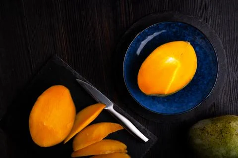 Ripe egyption Mango slices served  at black dish and blue plate at black tabl Stock Photos