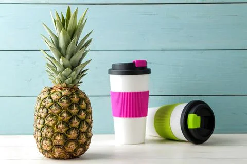 Ripe fruit pineapple and plastic thermoglass on a blue wooden background. sum Stock Photos