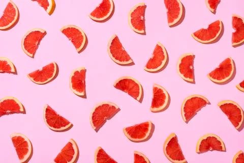 Ripe grapefruit slices pattern on pink background. Fresh fruits Stock Photos