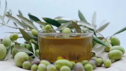 Ripe green olives falling down into transparent bowl with natural olive oil Stock Footage 165952914