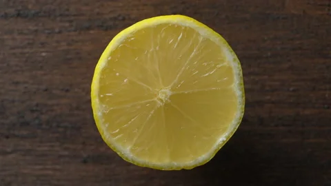 Ripe half yellow lemon citrus fruit on wooden background, closeup, rotate Stock Footage 236401844