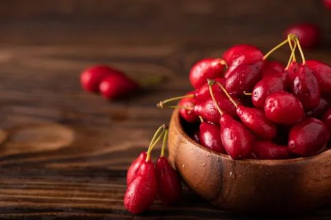 Ripe large dogwood berries in a wooden bowl Stock Photos