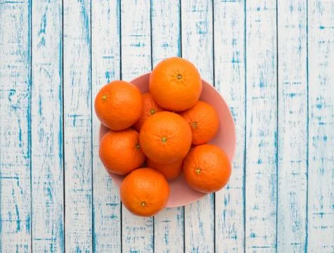 Ripe mandarins of large size in a plate on a wooden table in French style Stock Photos