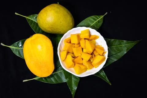 Ripe mango fruit and diced mango chunks showcasing healthy tropical snack c.. 스톡 사진