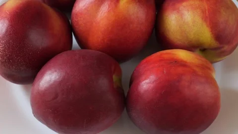 Ripe nectarine peaches rotating on a white background Stock Footage 337441389