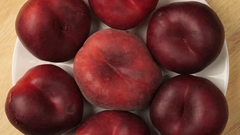 Ripe nectarines and flat peach rotating on a plate Stock Footage 344915461