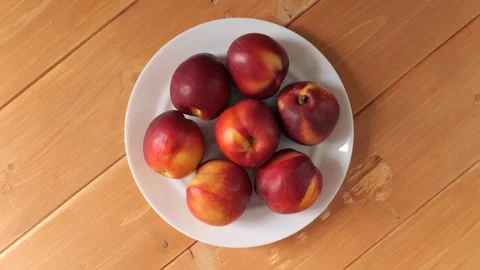Ripe nectarines rotating on a white plate Stock Footage 337011840