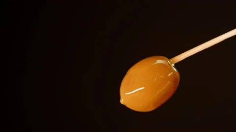 Ripe olive on black background close-up. Falling olive oil drops. Stock Footage 196180950
