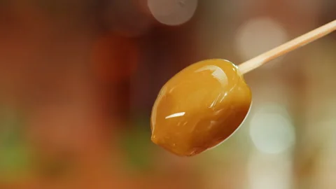 Ripe olive on brown background close-up. Falling olive oil drops. Stock Footage 196181774