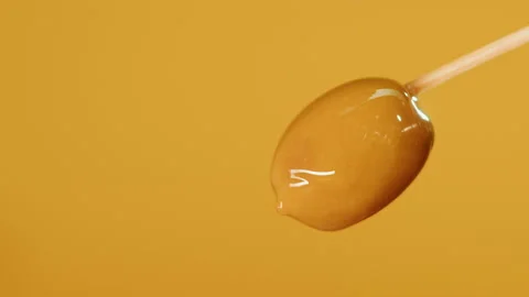 Ripe olive on yellow background close-up. Falling olive oil drops. Stock Footage 196180483