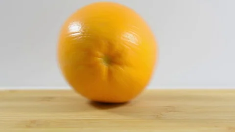 Ripe orange rolls on the table from left to right. Close-up Stock Footage 124084064