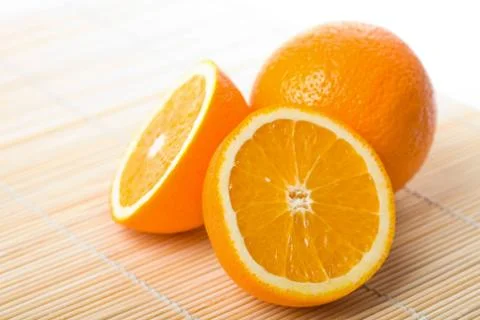 Ripe oranges over bamboo mat isolated Stock Photos