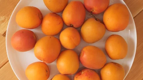 Ripe organic apricots rotating on a white plate Stock Footage 337441116