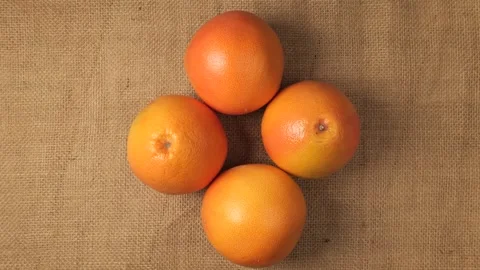 Ripe organic grapefruit rotating on a jute background Stock Footage 341822810