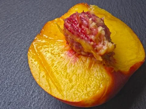 Ripe Peach on Dark Surface Highlighting Its Juicy Texture and Color Stock Photos