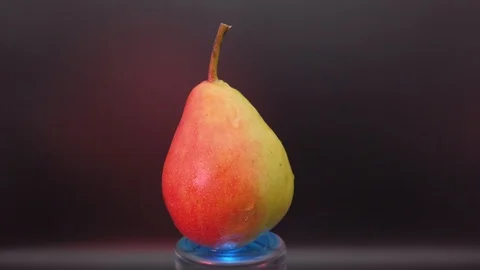 Ripe pear rotates on a black background Stock Footage 113554916