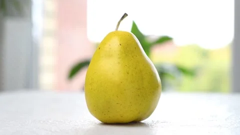 A ripe pear is spinning on the table. The camera moves around. Parallax effect. Stock Footage 161296028