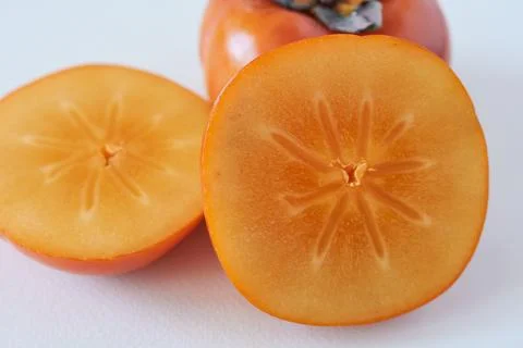 Ripe persimmon fruit on a white background. Close up. Stock Photos