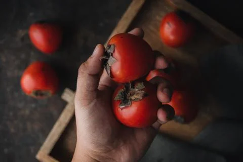 Ripe persimmon on rustic background Stock Photos