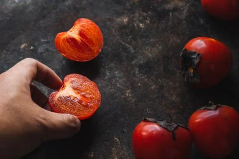 Ripe persimmon on rustic background Stock Photos