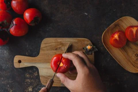 Ripe persimmon on rustic background Stock Photos