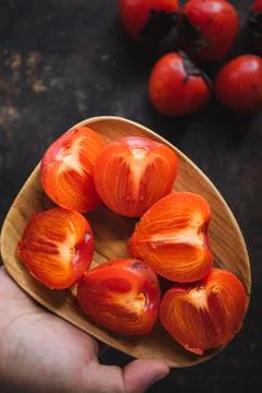 Ripe persimmon on rustic background Stock Photos