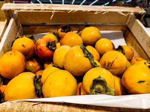 Ripe persimmons are in a box in the store Stock Photos