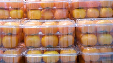 Ripe persimmons in plastic containers close-up in a supermarket. Stock Footage 219522602