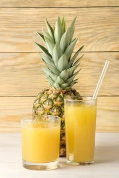 Ripe pineapple fruit and pineapple juice close-up on a natural wooden backgro Foto stock