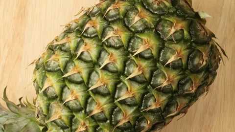 Ripe pineapple rotating on a wooden surface Stock Footage 344915508
