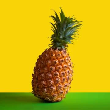 Ripe pineapple on a square frame. Yellow background. Copy space. Concept of a Stock Photos