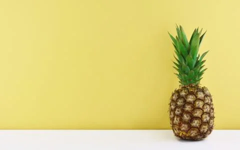 Ripe pineapple on yellow background. Stock Photos
