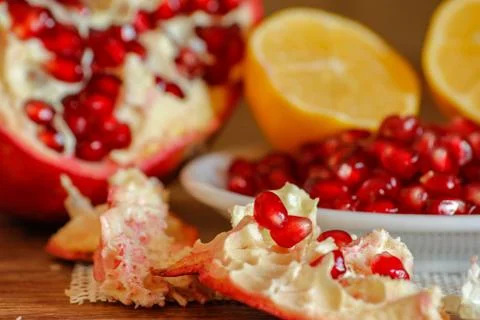 Ripe pomegranate and lemon on a ceramic plate Stock Photos