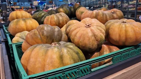 Ripe pumpkins in a plastic box in a grocery store or supermarket Stock Footage 253873386