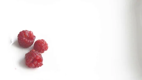 Ripe raspberries are slowly put on a plate by a woman's hand. Stock Footage 130113853