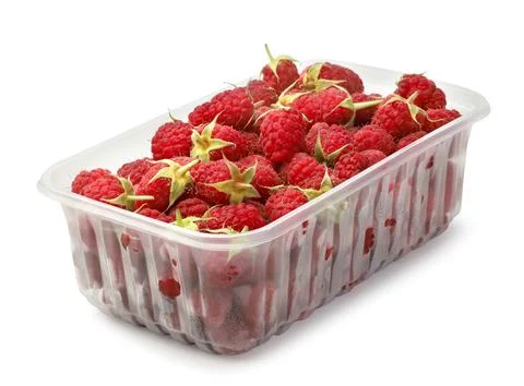 Ripe raspberries in a plastic container close-up on a white. Isolated Stock Photos