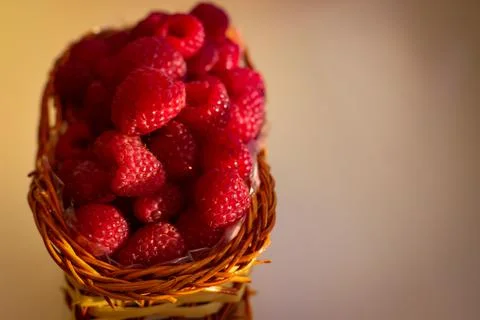 Ripe raspberry berries are folded into a wicker basket Stock Photos