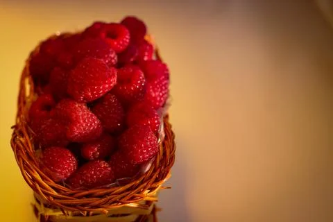 Ripe raspberry berries are folded into a wicker basket Stock Photos