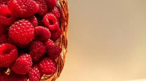 Ripe raspberry berries are folded into a wicker basket Stock Photos