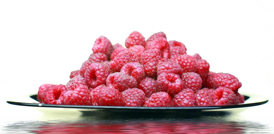 Ripe raspberry close-up. On the plate is a raspberry in the background Stock Photos